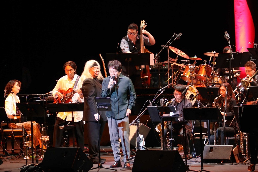 エリック・ミヤシロさん（左から３人目）が指揮するビッグバンドの演奏に乗せて歌う佐藤竹善さん（中央）＝浜松市中区のアクトシティ浜松
